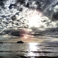 Scenic view of sea against cloudy sky at sunset