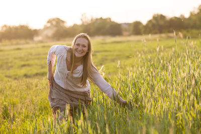 Woman smiling on field against sky