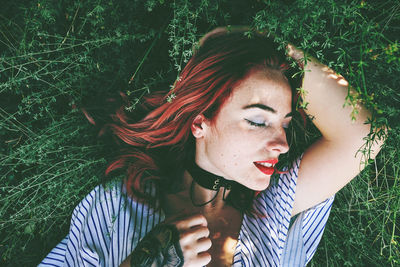 Portrait of young woman lying on field