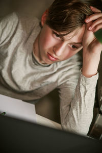 Young woman using mobile phone while lying on bed at home