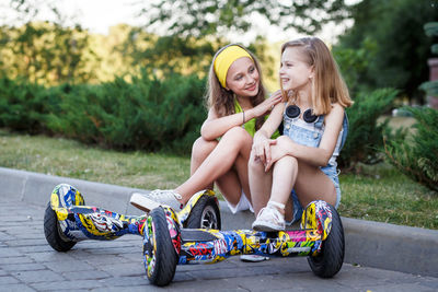 Friends with segway sitting on footpath