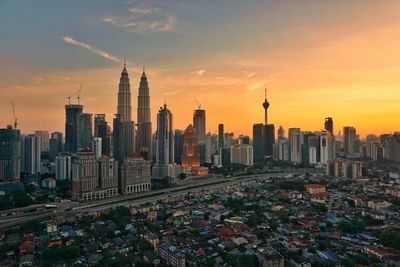 View of skyscrapers against cloudy sky during sunset