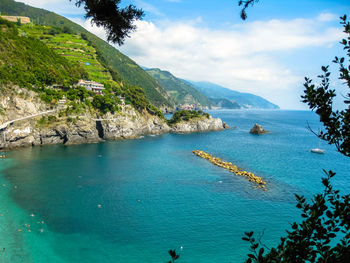 Green mountains by sea against sky