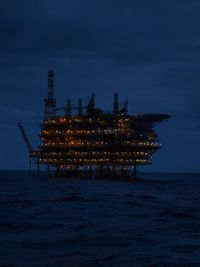 Scenic view of sea against sky with an oil platform on the horizon