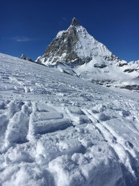 Scenic view of snowcapped mountain against blue sky