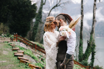 A happy couple in love and married embrace in nature by the lake and the misty mountains