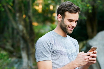 Young man using mobile phone outdoors