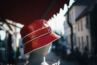 Close-up of red hat on mannequin in city