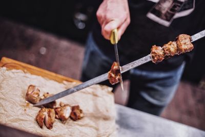 Midsection of person preparing food on barbecue grill