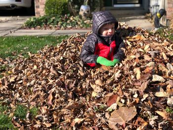 Full length of boy on leaves during winter