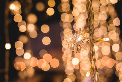 Defocused image of illuminated lights hanging at night