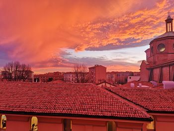 Houses in city against sky during sunset