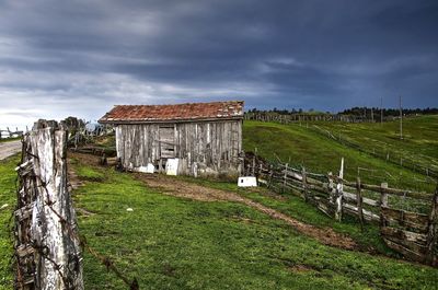 Scenic view of grassy field against cloudy sky