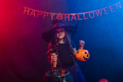 Portrait of cute girl wearing costume against black background