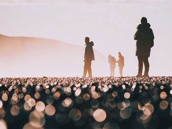 Silhouette people standing against clear sky during sunset