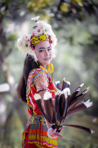 Portrait of smiling young woman in traditional clothing standing outdoors