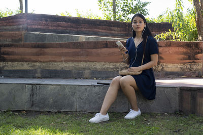 Portrait of a smiling young woman sitting on bench