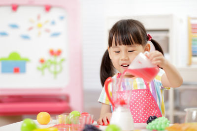 Young girl pretend playing food preparing at home 