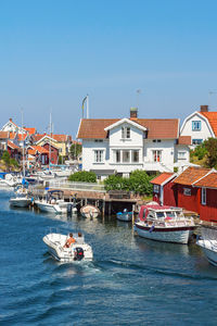 Motorboat heading in the narrow sea channel between houses