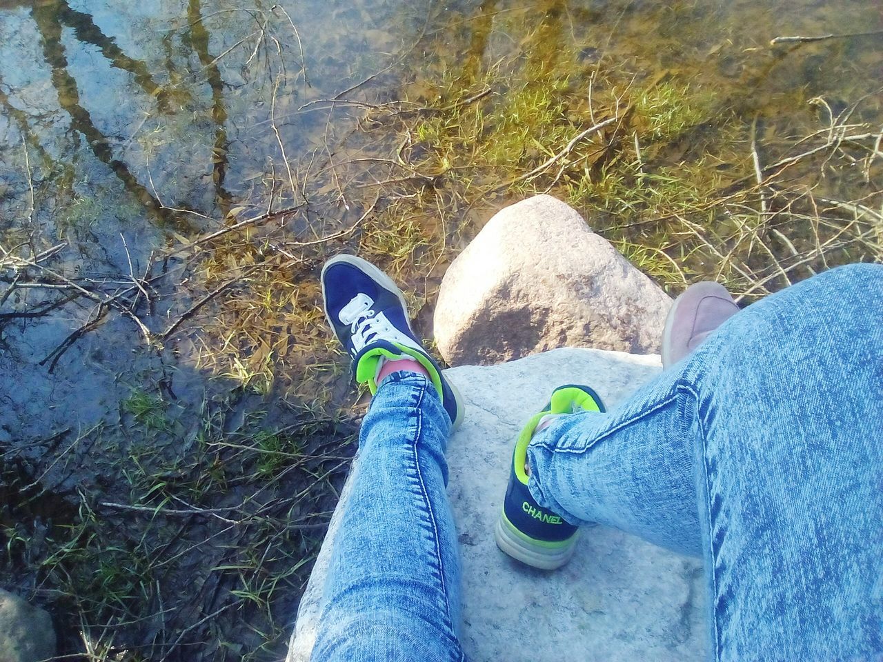 low section, human body part, personal perspective, human leg, shoe, one person, lifestyles, jeans, real people, day, leisure activity, outdoors, men, standing, close-up, canvas shoe, tree, water, one man only, people, adult, sky, adults only