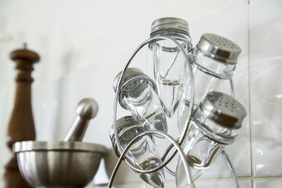Salt shakers by mortar and pestle on shelf in kitchen