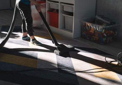 Child is vacuuming the carpet. boy helping with house cleaning. child development concept