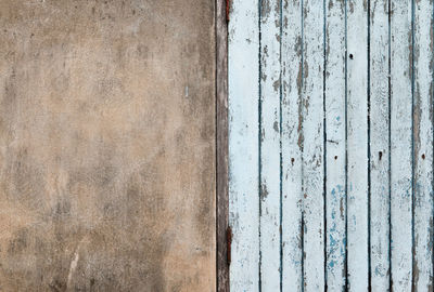 Old wooden plank door with concrete wall