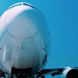 Close-up of an airplane against blue sky