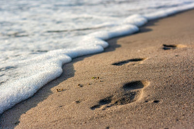 High angle view of footprints on sand at beach
