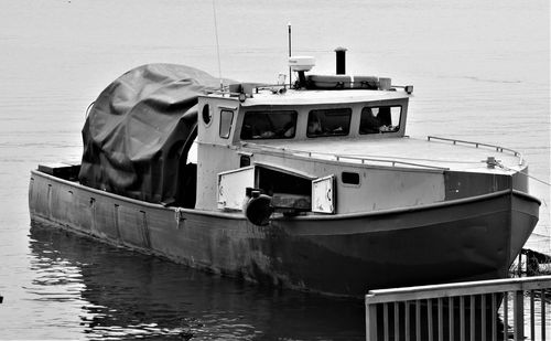 Boat moored on pier by sea