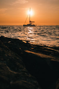 Silhouette sailboat on sea against sky during sunset