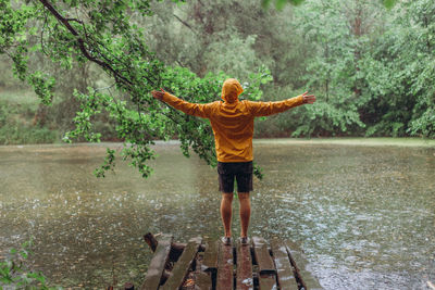 Full length rear view of man standing in rain