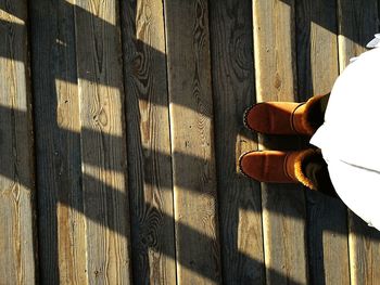 Low section of woman standing on floorboard