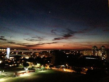 Illuminated cityscape against sky at night