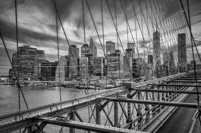 Bridge by buildings in city against sky