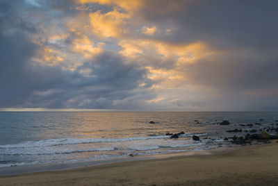 Scenic view of beach against sky during sunset