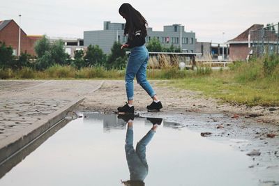 Reflection of woman in puddle