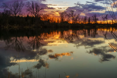 Reflection of trees in lake during sunset