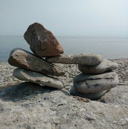 Stack of pebbles on beach against clear sky