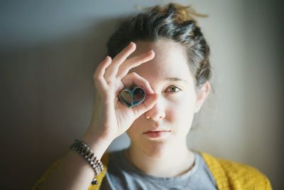 Portrait of woman looking through rolled up paper