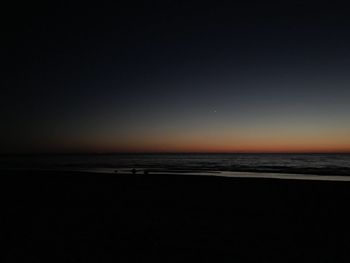 Scenic view of sea against clear sky at sunset