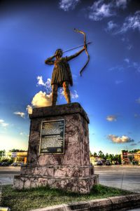 Statue in city against sky