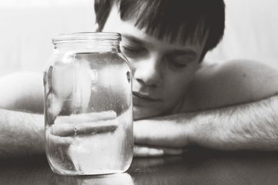 Close-up of man sleeping by water jar