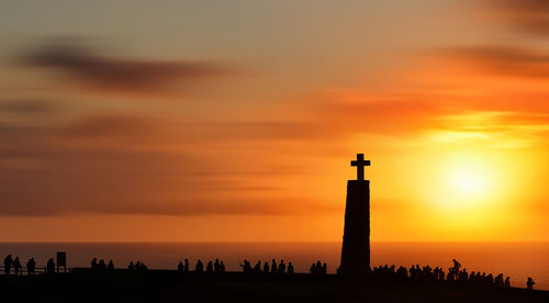 Silhouette of lighthouse against sky during sunset