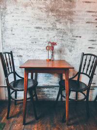 Empty chairs and table against wall