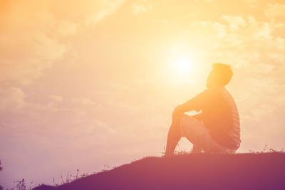 Rear view of silhouette man looking at sunset