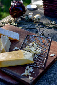 Still life with cheeses and cheese grater on wood cutting boards