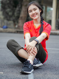 Portrait of a smiling young woman sitting outdoors