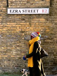 Rear view of woman with text against wall