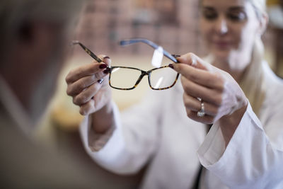 Optician helping customer to choose new spectacles